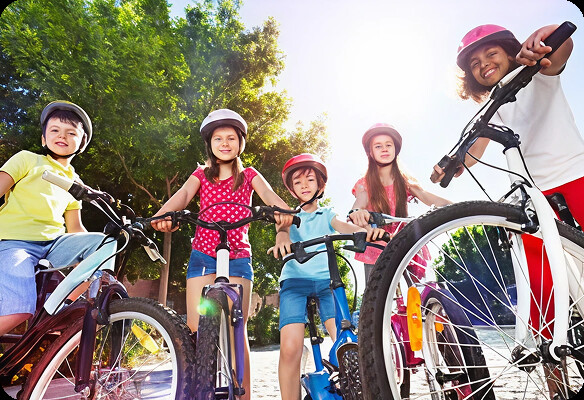 Children with bicycles wearing helmets